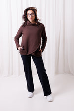 Modelka w brązowej bluzie Papaya z asymetrycznym przodem i przedłużonym tyłem, uszytej ze 100%  polskiej bawełny. Bluza ma kieszenie z zamkami.  odzież sportowa damska szyta w Polsce, Gdańsk.