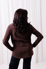 Modelka w brązowej bluzie Papaya z asymetrycznym przodem i przedłużonym tyłem, uszytej ze 100%  polskiej bawełny. Bluza ma kieszenie z zamkami.  odzież sportowa damska szyta w Polsce, Gdańsk.