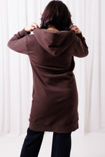 Tył długiej brązowej bluzy Long BalticBird z polskiej bawełny, przedłużony krój zasłaniający biodra i pośladki, sportowa odzież damska dla kobiet 30+ dopasowana do sylwetek jabłko, gruszka i kolumna; Gdańsk