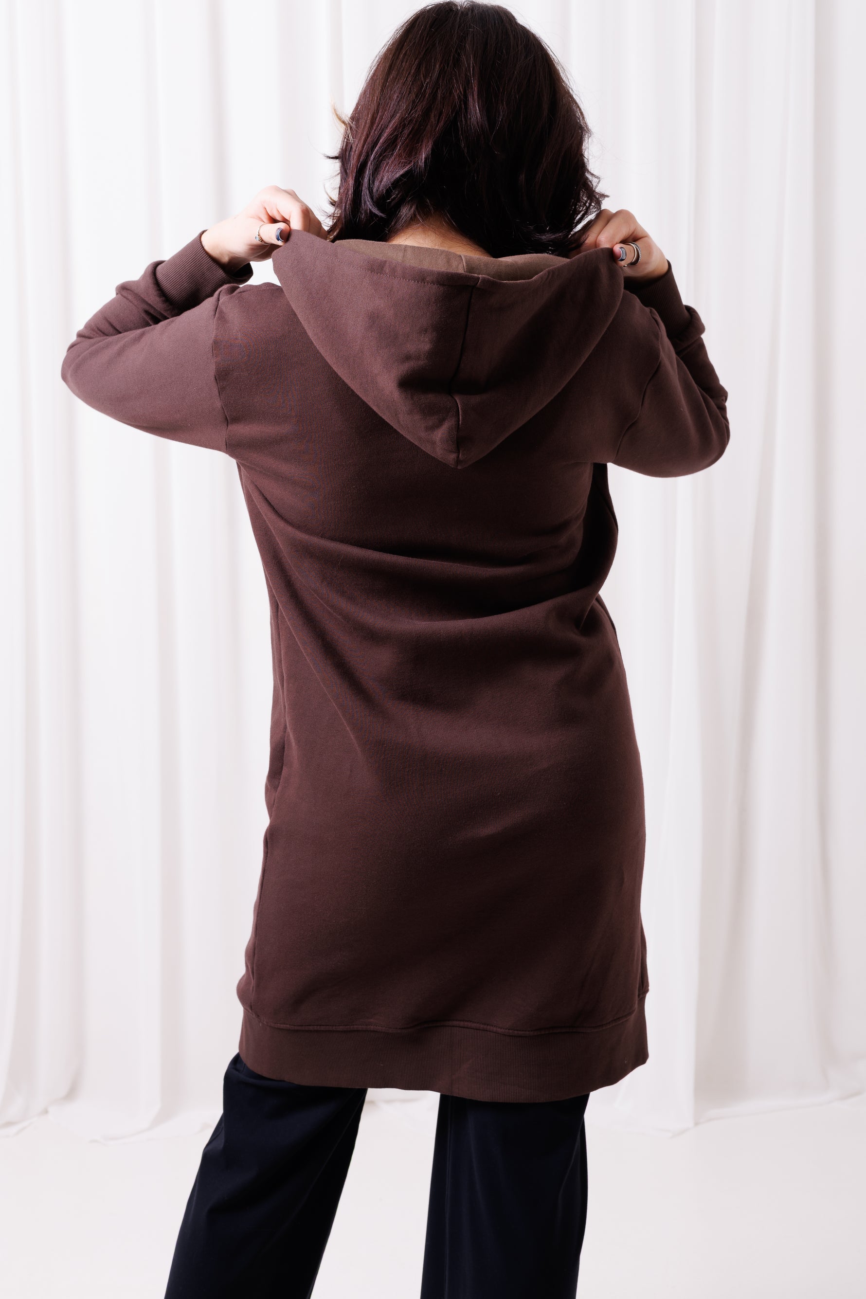 Tył długiej brązowej bluzy Long BalticBird z polskiej bawełny, przedłużony krój zasłaniający biodra i pośladki, sportowa odzież damska dla kobiet 30+ dopasowana do sylwetek jabłko, gruszka i kolumna; Gdańsk