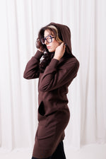 Modelka w długiej brązowej bluzie Long BalticBird z polskiej bawełny, zapinanej na suwak, z kieszeniami i wydłużonym tyłem;  Gdańsku; odzież sportowa dla kobiet 30+ dopasowana do sylwetek jabłko, gruszka i kolumna.